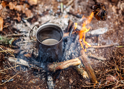 Heating water in a mugs over an outdoor fire