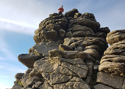 Person on top of a tor, having climbed up using a rope