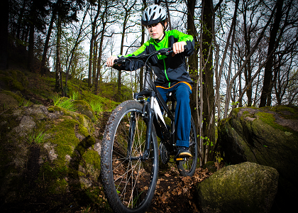 Boy on a mountain bike riding through a forest on Dartmoor