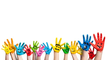 Brightly coloured painted children's hands with smiling faces painted on.